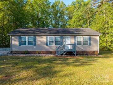 Charming single-story home with a well-maintained lawn and inviting front porch at 5039 Pine Springs Dr, Bessemer City, NC 28016
