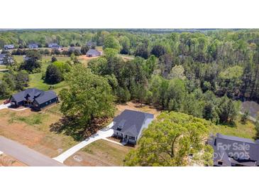 Expansive aerial view of a home with a gray roof, long driveway, and surrounding lush greenery at 515 Edmunds Ln # 38, Clover, SC 29710