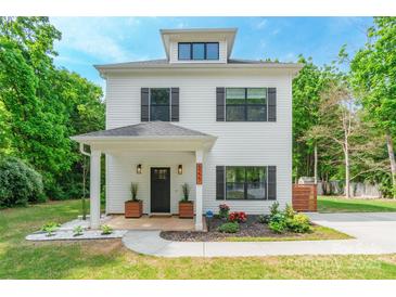 Charming two-story home features a covered porch, new landscaping, and updated finishes, perfect for modern living at 5227 Pinebrook Dr, Charlotte, NC 28208