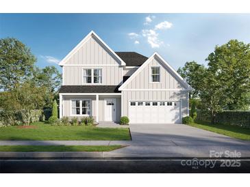 Charming two-story home featuring light siding, a well-manicured lawn, and an attached two car garage at Lot 4 Henderson Cir, Harrisburg, NC 28075