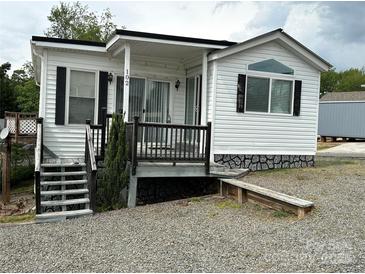 Charming single-story home with white siding, black shutters, and a cozy front porch at 102 Eagle Ln, New London, NC 28127