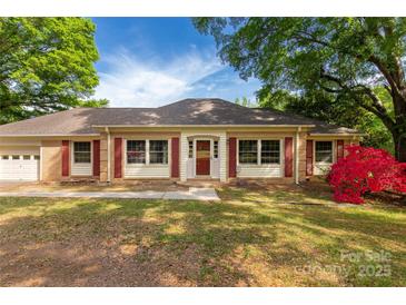 Charming single-story home featuring red shutters, brick accents, a well-maintained yard, and a beautiful red azalea bush at 2007 Green Peach Rd, Lancaster, SC 29720