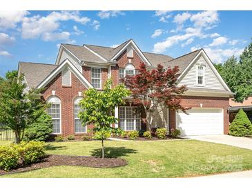 Charming brick home with manicured lawn, mature trees, and attached two-car garage at 3007 Sandbox Cir, Indian Trail, NC 28079