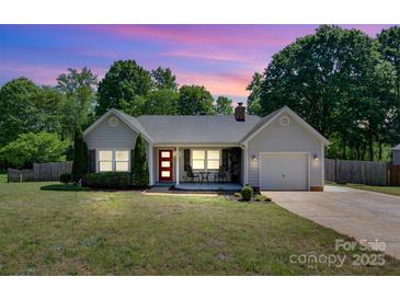 Charming single story home boasts a lovely landscaped yard, inviting front porch, and attached garage at 308 Southland Rd, Huntersville, NC 28078