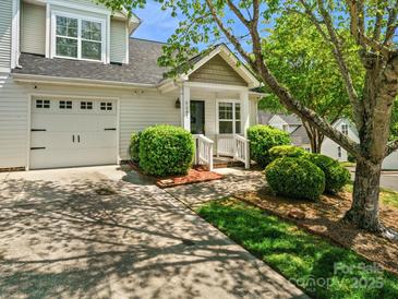 Charming home exterior featuring a one-car garage, lush landscaping, and a welcoming front porch at 6647 Vlosi Dr, Charlotte, NC 28226