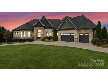 Beautiful stone and brick home with an attached three-car garage and a well-manicured lawn at 767 Pinnacle Dr, Iron Station, NC 28080