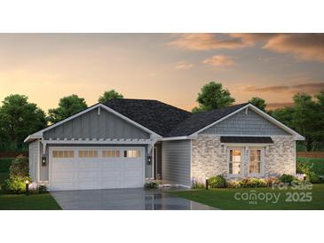 Charming single-story home featuring stone accents, a two-car garage, and manicured landscaping at sunset at Lot 2 Rocky River Crossing Rd, Harrisburg, NC 28075