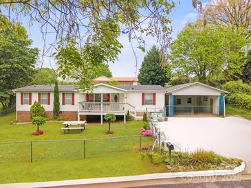 Charming one-story home with red shutters, front porch and fenced yard on a landscaped lot at 1106 3Rd Sw Ave, Hickory, NC 28602