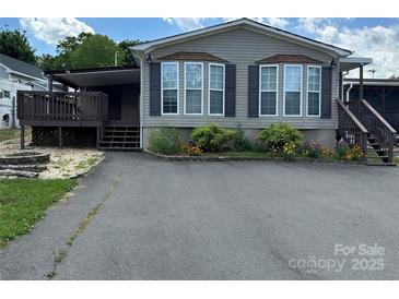 Charming home featuring well-maintained landscaping, flowerbeds, dark shutters, and a covered porch on a sunny day at 116 Dove Ln, New London, NC 28127