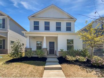 Charming two-story home with a welcoming front porch and well-maintained landscaping at 11933 Silverheel Ln, Huntersville, NC 28078