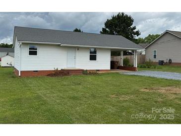 Charming single-story home featuring white siding and a covered carport, set on a lush green lawn at 2109 Boggs St, Lincolnton, NC 28092