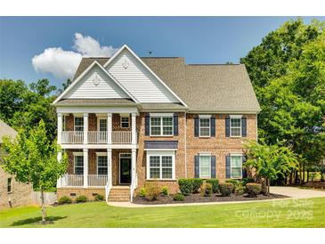 Charming two-story brick home featuring a double-decker porch and well-manicured lawn and landscape at 4704 Amberside Dr, Rock Hill, SC 29732
