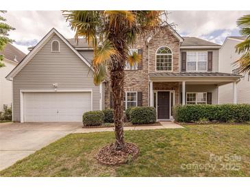 Charming two-story home with stone accents, a well-manicured lawn, and a two-car garage at 5707 Parkstone Dr, Matthews, NC 28104