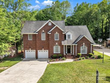 Charming two-story brick home with a well-manicured lawn, two-car garage and lovely landscaping at 5775 Monticello Nw Dr, Concord, NC 28027