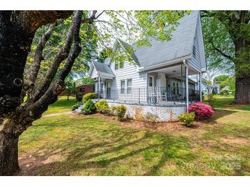 Charming home featuring a covered front porch with seating and beautifully landscaped front yard at 602 W 6Th St, Newton, NC 28658