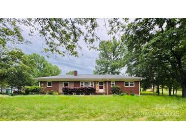 Charming brick ranch-style home with a well-manicured lawn and mature trees at 6615 Mount Holly Rd, Charlotte, NC 28214