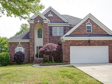Charming two-story brick home with manicured lawn and attached two-car garage at 7642 Horseshoe Creek Dr, Huntersville, NC 28078