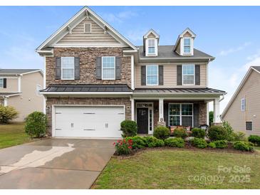 Charming two-story home featuring a stone facade, manicured landscaping, and an attached two-car garage at 79044 Ridgehaven Rd, Lancaster, SC 29720