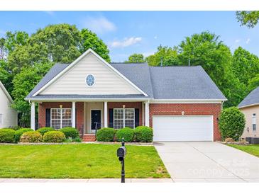 Charming single-story home with brick facade, manicured lawn, and attached two-car garage at 8120 Calistoga Ln, Waxhaw, NC 28173