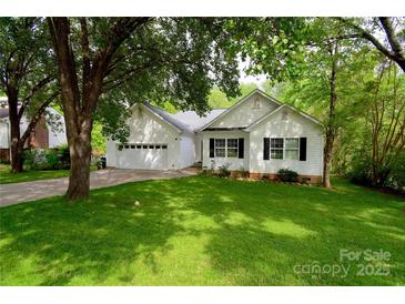 Charming white home with a well-manicured lawn and mature trees, providing shade and curb appeal at 8200 Park Vista Cir, Charlotte, NC 28226