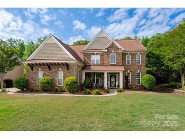 Beautiful brick two-story home with a well-manicured lawn and lovely landscaping at 900 Springwood Dr, Waxhaw, NC 28173