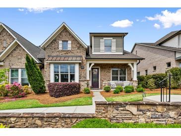 Charming brick home featuring a cozy front porch and professionally landscaped front yard at 9319 Highclere Ct, Matthews, NC 28105
