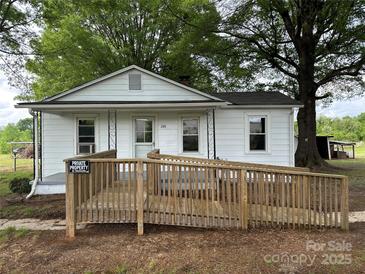 Charming single-story home with white siding, front ramp, and mature trees at 135 Hendren Ln, Hiddenite, NC 28636