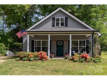 Charming home featuring a welcoming porch, neat landscaping, and an American flag at 135 Westerwood Dr, Rock Hill, SC 29732