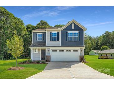 Charming two-story home featuring a two-car garage, well-manicured lawn, and a combination of gray and blue siding at 2106 Columbidae Ln, Gastonia, NC 28052