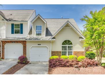 Charming townhome featuring a one-car garage, arched window, and beautifully landscaped front yard at 5206 Fire Water Ln, Fort Mill, SC 29707