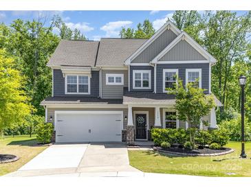 Charming two-story home featuring a two-car garage, stone accents, and a well-maintained front yard with mature trees at 1552 Trentwood Dr, Fort Mill, SC 29715