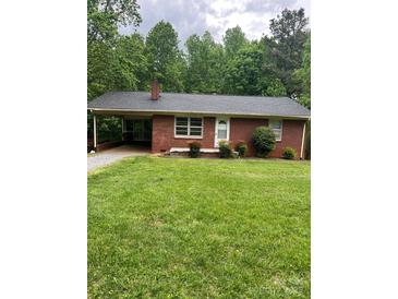 Charming one-story brick home featuring a carport, manicured lawn, and mature trees at 755 Victory Grove Church Rd, Lincolnton, NC 28092