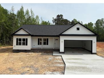 Charming single-story home featuring a modern black and white exterior, attached garage, and a well-manicured lawn at Lot 9 Lilly Pad Dr, Salisbury, NC 28146