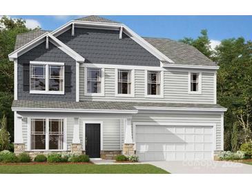 Two-story home with a black front door, gray shingles, siding, a two-car garage, and manicured landscaping at 1227 Fremont Dr, Wingate, NC 28174