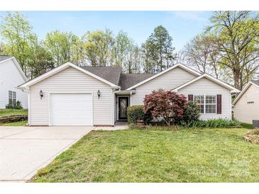 Charming one-story home featuring a garage, landscaped front yard, and manicured lawn at 12628 Waterfall Pl, Charlotte, NC 28278