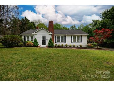 Charming single-story home with a brick chimney, well-manicured lawn, and beautiful landscaping at 166 Still Ave, Fort Mill, SC 29715