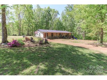 Inviting single-story home featuring a charming front porch and a spacious front yard at 212 Davies Cir, Cleveland, NC 27013