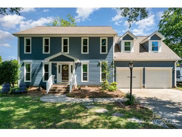 Charming two-story home with blue siding, manicured lawn and attached two-car garage on a sunny day at 2278 Jon Chris Dr, Harrisburg, NC 28075