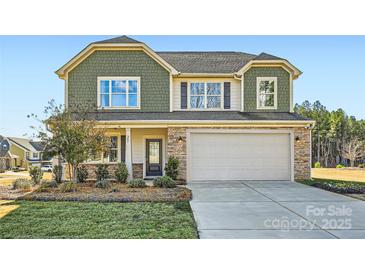 Charming two-story home with a stone-accented facade, two-car garage, and well-maintained landscaping at 247 Tackle Box Dr, Troutman, NC 28166