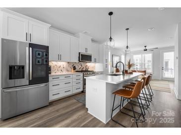 Modern kitchen featuring stainless steel appliances, white cabinetry, and a large center island with seating at 4002 Tundra Rd, Charlotte, NC 28203
