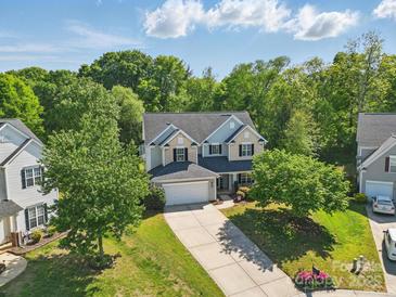 Traditional two-story home with manicured lawn and a driveway, surrounded by mature trees at 4853 Walnut Grove St, Harrisburg, NC 28075