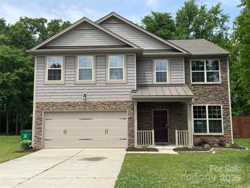 Charming two-story home with stone and siding, featuring a two-car garage and landscaped front yard at 5619 Fenway Dr, Charlotte, NC 28273
