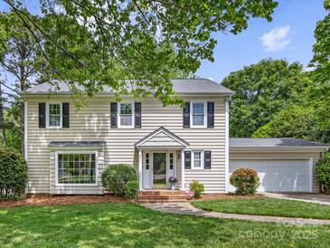 Charming two-story home featuring a well-manicured lawn, attached garage, and inviting front entrance at 5817 Portburn Rd, Charlotte, NC 28211