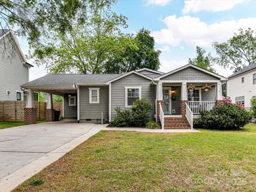 Charming single-story home with gray siding, well-maintained lawn, brick accents, and covered carport at 335 Greystone Rd, Charlotte, NC 28209
