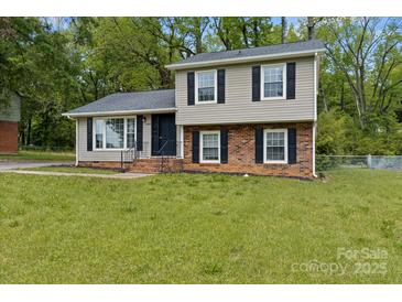 Charming two-story home with a combination of brick and vinyl siding and black shutters at 6443 Eaglecrest Rd, Charlotte, NC 28212