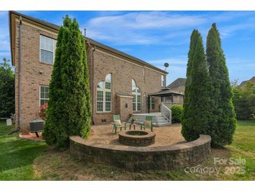 Beautiful brick home featuring a patio with a fire pit and a charming gazebo-covered deck at 1116 Crooked River Dr, Waxhaw, NC 28173