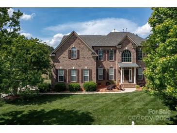 Traditional two-story brick home with manicured lawn and shuttered windows at 1116 Crooked River Dr, Waxhaw, NC 28173