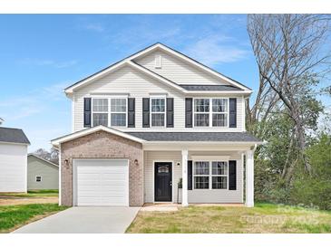 Charming two-story home with a brick facade and a well-manicured lawn on a sunny day at 1148 Thayer Glen Ct, Charlotte, NC 28213