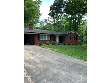 Charming brick home featuring a well-manicured lawn, a cozy front porch and driveway at 137 Deal Ln, Statesville, NC 28677