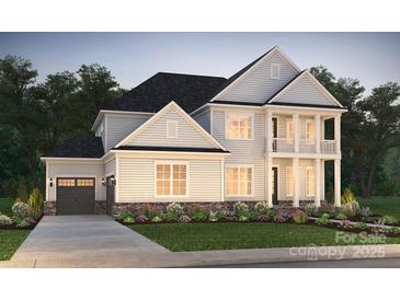 Charming two-story home with a covered porch, balcony, landscaped yard, and an attached two-car garage at 14133 White Gardens Ln # 12, Huntersville, NC 28078